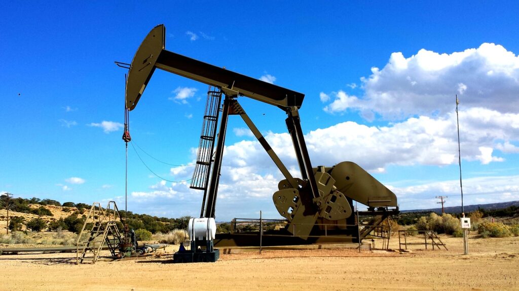 Oil crane on a dry land with blue sky behind